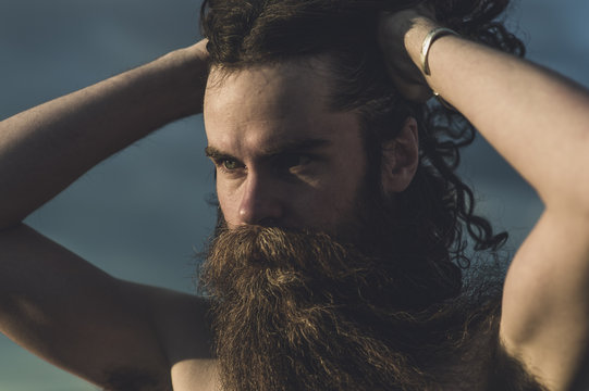 A handsome bearded man with his dogs in beautiful desert hot springs during the golden hour