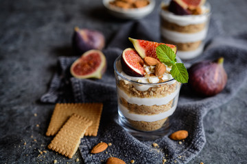 Layered mascarpone dessert with crushed vanilla biscuits, figs and almonds - obrazy, fototapety, plakaty