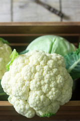 Cauliflower and cabbage on a wooden background. Rustic style, selective focus.