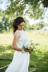 Beautiful bride outdoors on the meadow on a wedding day. Joyful moment of happiness
