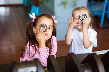 two happy little girls playing machine parts, playing with car parts.