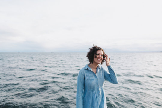 Portrait of young happy woman hanging out in near ocean