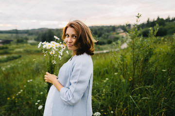Pregnant female with camomile bouquet