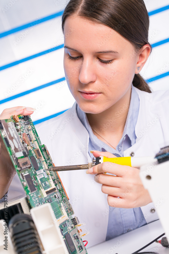 Wall mural Young woman fix PC component in service center