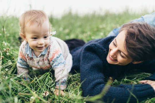Mother and her baby girl playing in grass