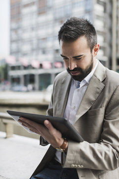Businessman using digital tablet outdoor.