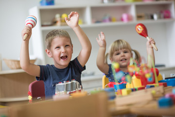 Happy smiling caucasian kids are playing with montessori toys