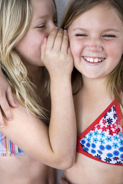 Two Girls Wearing Bathing Suits Telling Secrets