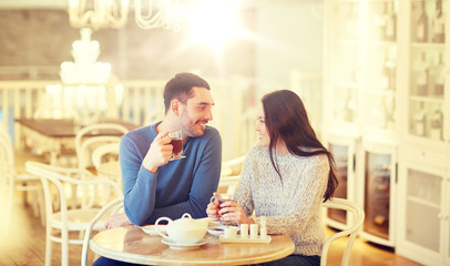 Obraz na płótnie Canvas happy couple drinking tea at cafe