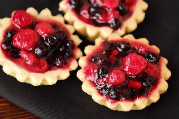 Delicious berry cakes and a napkin on the table 