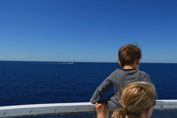 Fototapeta premium Ein Kind und seine Mutter beobachten das Boot