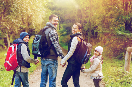 happy family with backpacks hiking