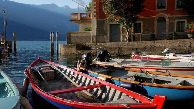 Boats are at the pier on Lake Garda on a beautiful summer sunny morning