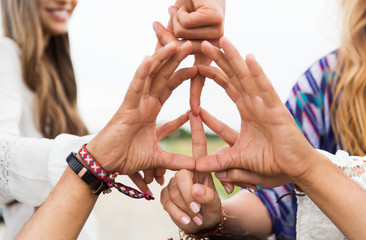 hands of hippie friends showing peace sign