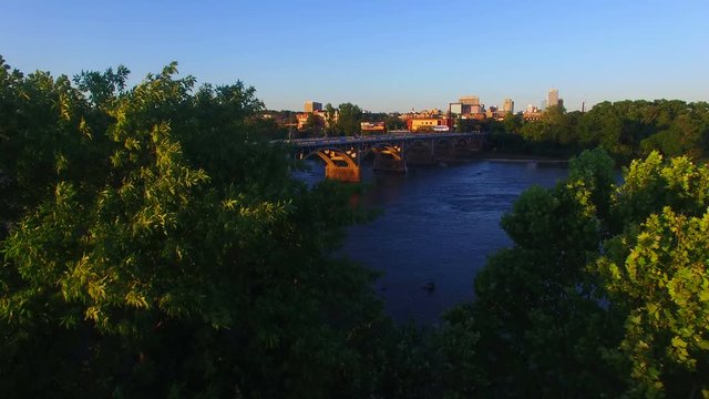 Rising reveal drone shot from across the Congaree River, comes over the trees to show the beautiful downtown skyline of Columbia South Carolina