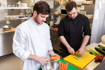 chef and cook cooking food at restaurant kitchen