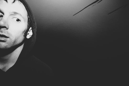 Portrait of man with surprised and disturbed face, hiding in urban tunnel