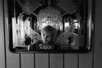 Little girl behind an engraved window.