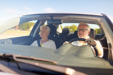 happy senior couple driving in car