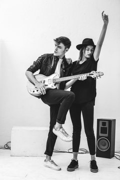 Rockers couple composing with electric guitar in recording studio.