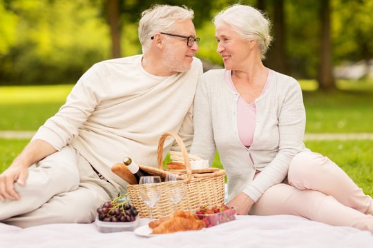 happy senior couple having picnic at summer park