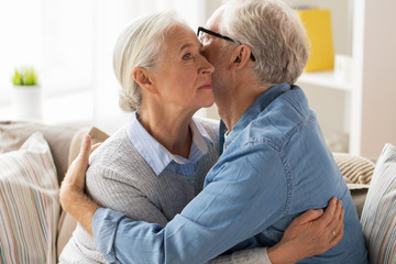 sad senior couple hugging at home