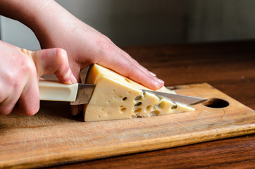 Slicing cheese on a wooden board.