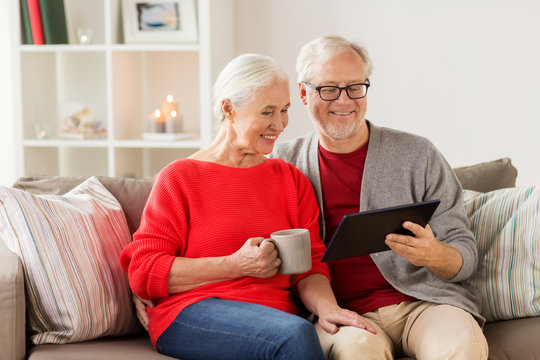 happy senior couple with tablet pc at christmas