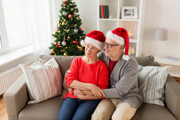 happy senior couple in santa hats at christmas