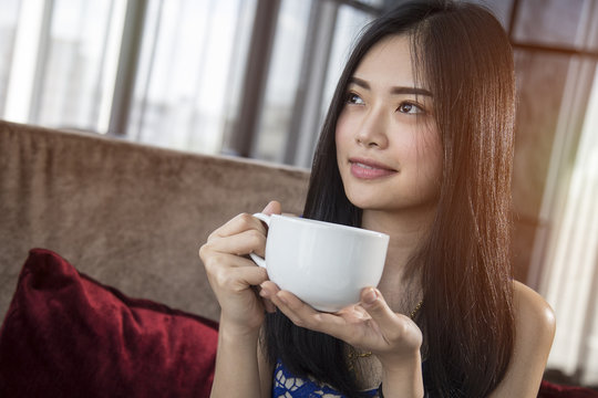 Beautiful Asian Girl With Cup Of Cofee Mocha Drinking In Luxury Home With Sunlight In Windows.  Copy Space For Text.