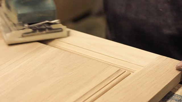 Carpenter is polishing wood surface