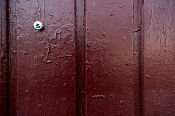 Texture of an old painted brown wooden wall with a screwdriver