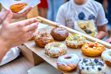 Close-up of tasty baked donuts with glazing and berries in sunli