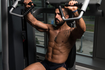 Fototapeta na wymiar Fitness Man Exercising Chest In The Gym