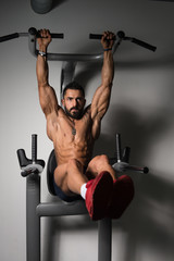 Man Doing Pull-up Bar Abdominal Exercise in Gym