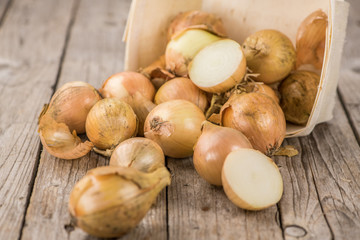 Wooden table with White Onions, selective focus