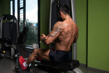 Fototapeta na wymiar Athletic Man Doing Exercise for Back in Gym