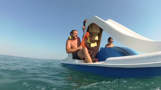 Dad pulls his son out of the sea into the catamaran
