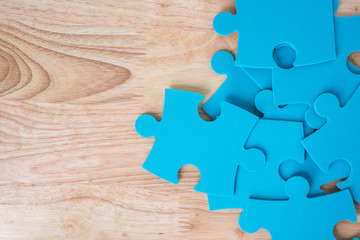 blue jigsaw puzzle pieces on wooden background