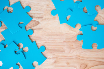 blue jigsaw puzzle pieces on wooden background