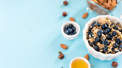 Perfect breakfast. Oatmeal with blueberries. Healthy eating for the whole family. wood background.