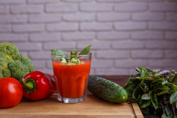 Diet concept, healthy lifestyle, low calorie food. Tomato smoothie with basil and cucumber. Detox and dietary eating on wooden table, copy space