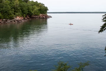Wandcirkels aluminium Silhouette of a kayaker on scenic Madeline Island in Lake Superior © karagrubis