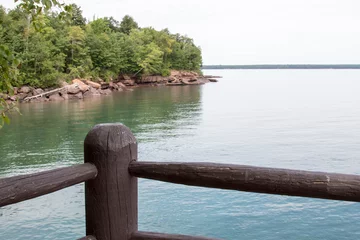 Zelfklevend Fotobehang Wooden fence and scenic shoreline of Madeline Island in Lake Superior © karagrubis