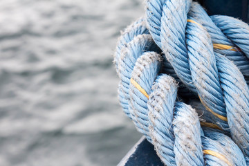 Close up of a blue nylon rope against water on a boat
