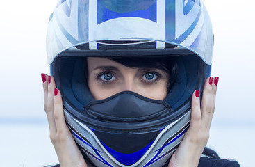 Young woman's beautiful amazing blue eyes in a black helmet with an open visor