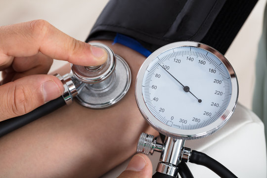 Doctor Checking Blood Pressure Of Patient