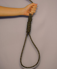 Female hand holding rope loop, suicide concept.