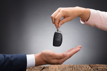Car Dealer Giving Key To Businessperson