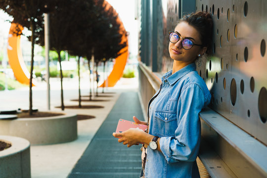 Smiling girl with notepad at street